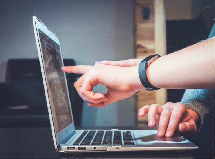 Hands pointing at laptop